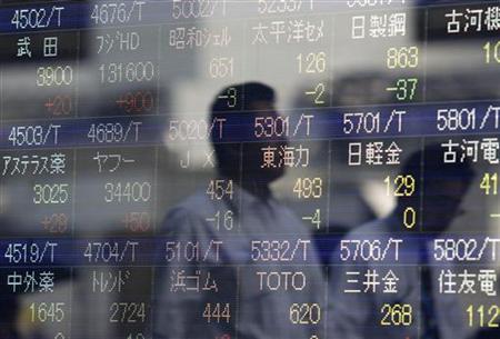 Passers-by are reflected in a stock index board outside of a brokerage in Tokyo Passers-by are reflected in a stock index board outside of a brokerage in Tokyo