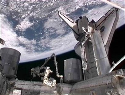 The space shuttle Atlantis is seen docked to the International Space Station with the Earth in the background. The space shuttle Atlantis is seen docked to the International Space Station with the Earth in the background.