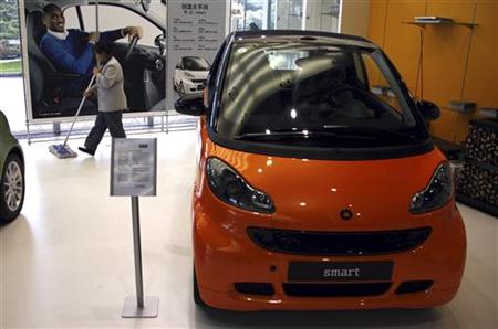 A cleaner walks past a Smart car displayed in front of a poster featuring U.S. NBA basketball superstar Kobe Bryant in a showroom in Beijing A cleaner walks past a Smart car displayed in front of a poster featuring U.S. NBA basketball superstar Kobe Bryant in a showroom in Beijing