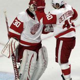 Detroit Red Wings goaltender Chris Osgood (L) is congratulated by Henrik Zetterberg after defeating the Chicago Blackhawks in their NHL hockey game in Chicago October 9, 2010. REUTERS