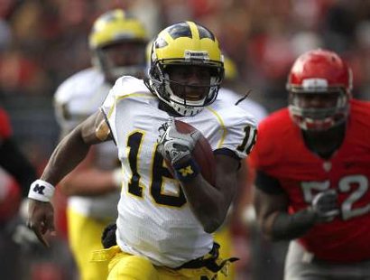 Michigan quarterback Denard Robinson (16) runs the ball by Ohio State defender Johnathan Hankins (52) during the second quarter of their game in Columbus, Ohio, November 27, 2010. REUTERS Michigan quarterback Denard Robinson (16) runs the ball by Ohio State defender Johnathan Hankins (52) during the second quarter of their game in Columbus, Ohio, November 27, 2010. REUTERS