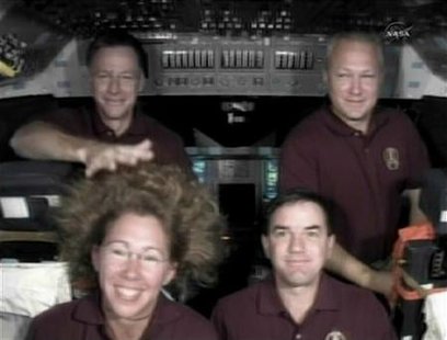 Space shuttle Atlantis Commander Chris Ferguson reaches in to tame the zero-G hairdo of fellow astronaut Sandy Magnus. Space shuttle Atlantis Commander Chris Ferguson reaches in to tame the zero-G hairdo of fellow astronaut Sandy Magnus.