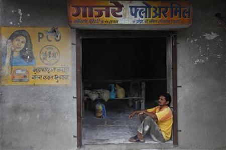 An employee sits outside a flour mill in the Ralegan Siddhi village, located in the Ahmednagar district about 250km (155 miles) south east o An employee sits outside a flour mill in the Ralegan Siddhi village, located in the Ahmednagar district about 250km (155 miles) south east o