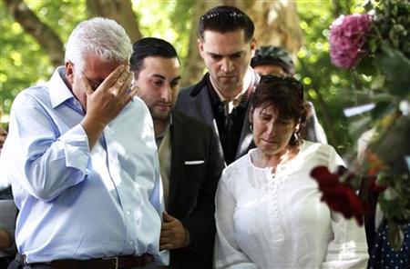Father Mitch Winehouse, brother Alex, former boyfriend Reg Traviss and mother Janis look at look at memorabilia left by fans of Amy Winehous Father Mitch Winehouse, brother Alex, former boyfriend Reg Traviss and mother Janis look at look at memorabilia left by fans of Amy Winehous
