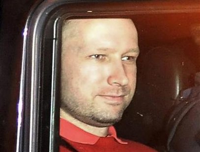 Norwegian Breivik, man accused of a killing spree and bomb attack in Norway, sits in the rear of a vehicle as he is transported in a police 