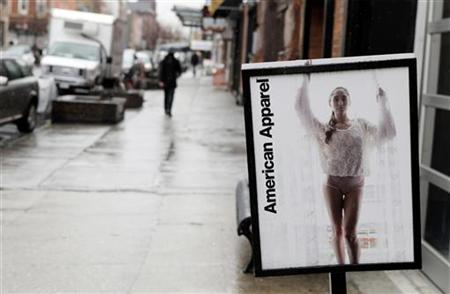 Pedestrians walk past an American Apparel sign outside one of their stores in New York Pedestrians walk past an American Apparel sign outside one of their stores in New York
