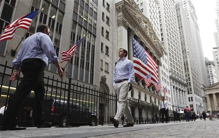 Pedestrians walk past the outside of the New York Stock Exchange in New York