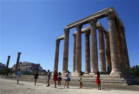 Tourists walk past the Temple of the Olympian Zeus in Athens Tourists walk past the Temple of the Olympian Zeus in Athens