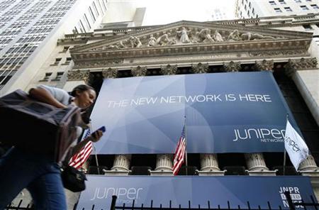 A woman walks past a banner with the logo of Juniper Networks Inc. covering the facade of the New York Stock Exchange A woman walks past a banner with the logo of Juniper Networks Inc. covering the facade of the New York Stock Exchange