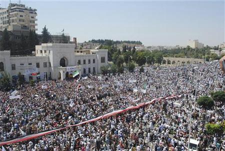 A giant Syrian flag is held by the crowd during a protest against President Bashar al-Assad after Friday prayers in the city centre of Hama A giant Syrian flag is held by the crowd during a protest against President Bashar al-Assad after Friday prayers in the city centre of Hama