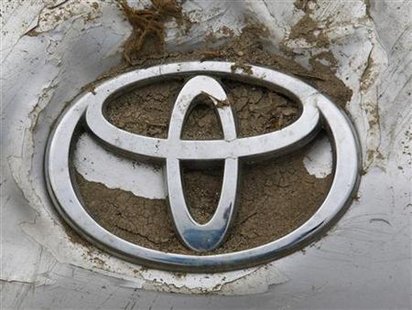 A Toyota logo on a damaged car is seen at a dump site for tsunami debris near Sendai airport A Toyota logo on a damaged car is seen at a dump site for tsunami debris near Sendai airport