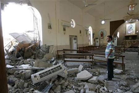 A man stands among debris inside a church after a bomb attack in central Kirkuk