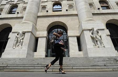 A woman walks past Milan Stock Exchange A woman walks past Milan Stock Exchange