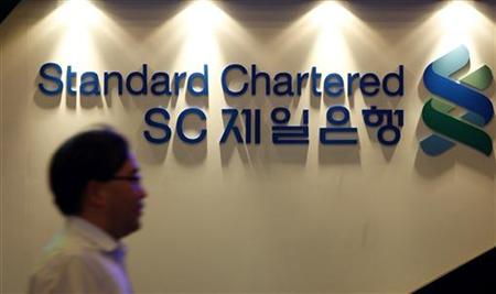 Employee at SC First Bank walks past its logo at the bank's headquarters in Seoul Employee at SC First Bank walks past its logo at the bank's headquarters in Seoul