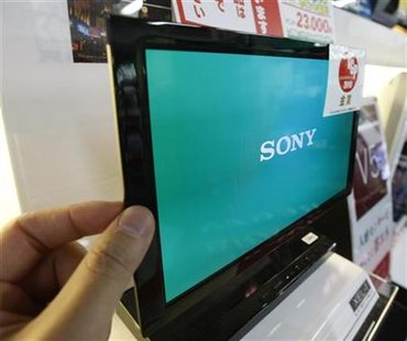 A man touches Sony's OLED TV during a photo opportunity at an electronic shop in Tokyo