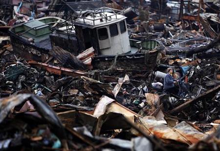 A woman rides her bicycle past a boat in the rubbles of Kesennuma, Miyagi Prefecture A woman rides her bicycle past a boat in the rubbles of Kesennuma, Miyagi Prefecture