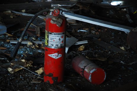 A used fire extinguisher sits outside. A used fire extinguisher sits outside.