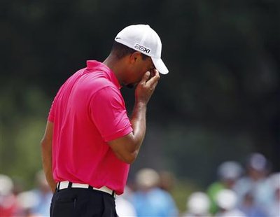 Tiger Woods of the U.S. wipes sand from his eyes after hitting from a sand trap on the ninth hole during the first round of the 93rd PGA Cha Tiger Woods of the U.S. wipes sand from his eyes after hitting from a sand trap on the ninth hole during the first round of the 93rd PGA Cha