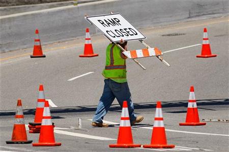 A worker removes road barriers from an onramp as the 405 freeway reopens after the demolition of the Mulholland Drive bridge in Los Angeles A worker removes road barriers from an onramp as the 405 freeway reopens after the demolition of the Mulholland Drive bridge in Los Angeles