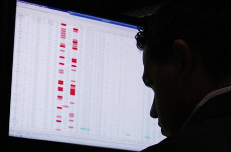 A trader is silhouetted against his computer screen as he works on the floor of the New York Stock Exchange in New York A trader is silhouetted against his computer screen as he works on the floor of the New York Stock Exchange in New York