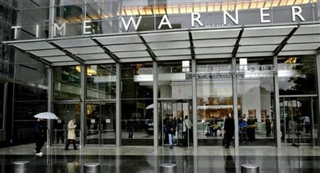 People walk in front of the Time Warner Inc. headquarters building at Columbus Circle in New York Oc..