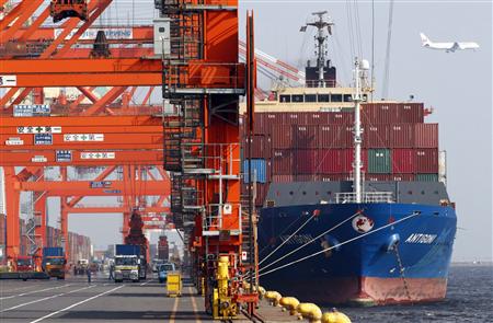 Workers load a container onto a cargo ship at a port in Tokyo Workers load a container onto a cargo ship at a port in Tokyo