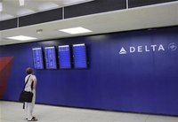 A man looks at a monitor for arrival and departure flight information at the Delta airline terminal at JFK Airport in New York