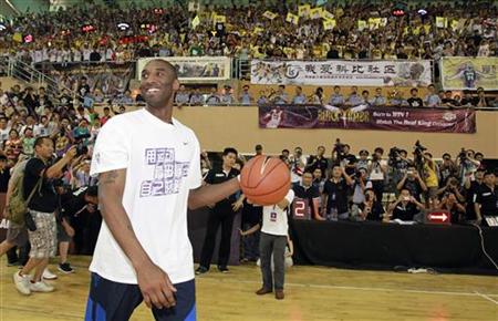 NBA basketball player Bryant of the Los Angeles Lakers smiles to fans upon his arrival at a stadium during his 2011 China Tour in Changsha