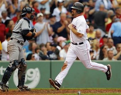 New York Yankees' Cervelli watches the Boston Red Sox Youkilis cross the plate for a run during their MLB baseball game in Boston New York Yankees' Cervelli watches the Boston Red Sox Youkilis cross the plate for a run during their MLB baseball game in Boston