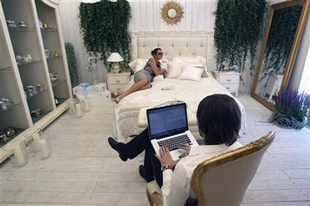 A man sits with his computer at a furniture and chinaware booth during the Summer Fair in Moscow A man sits with his computer at a furniture and chinaware booth during the Summer Fair in Moscow