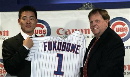 Former Japanese baseball player Kosuke Fukudome shows his new jersey with Chicago Cubs general manager Jim Hendry during a news conference i Former Japanese baseball player Kosuke Fukudome shows his new jersey with Chicago Cubs general manager Jim Hendry during a news conference i