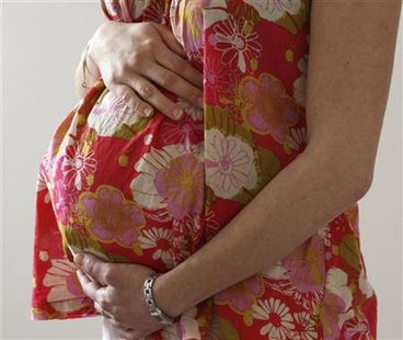 A woman holds her stomach at the last stages of her pregnancy in Bordeaux A woman holds her stomach at the last stages of her pregnancy in Bordeaux