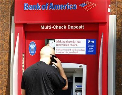 A customer stands at an ATM machine at a Bank of America office in Burbank, California A customer stands at an ATM machine at a Bank of America office in Burbank, California