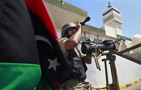 A Libyan rebel fighter keeps watch after rebels seized control of the Gaddafi army women's officer training center in Tripoli's Qarqarsh dis A Libyan rebel fighter keeps watch after rebels seized control of the Gaddafi army women's officer training center in Tripoli's Qarqarsh dis