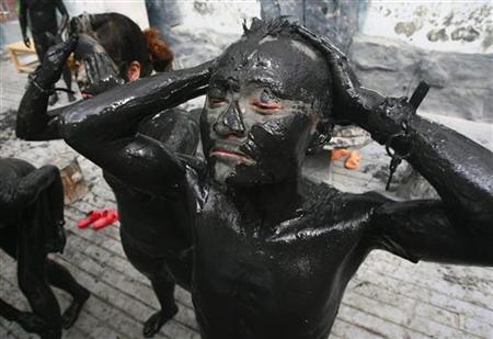 Visitors cover their bodies with black mud at a tourist resort in Daying County Visitors cover their bodies with black mud at a tourist resort in Daying County