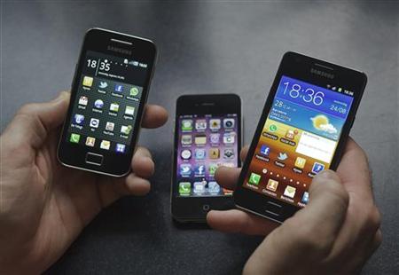 A man holds a Samsung S II and Samsung Ace smartphones next to an Apple iPhone 4 in Houten A man holds a Samsung S II and Samsung Ace smartphones next to an Apple iPhone 4 in Houten