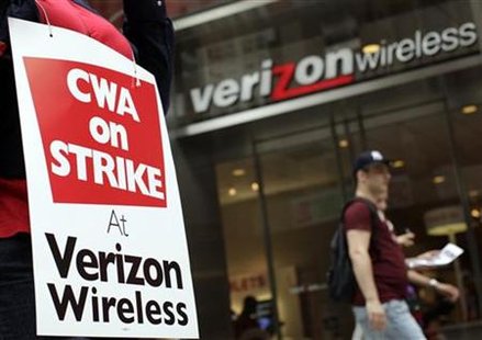 A striking Verizon worker walks the picket line in front of a Verizon wireless store in New York A striking Verizon worker walks the picket line in front of a Verizon wireless store in New York