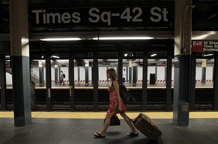 A woman walks through the Times Square subway station after the last subway has left A woman walks through the Times Square subway station after the last subway has left