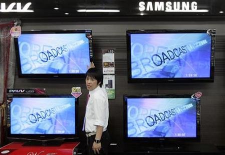 An electronics shop salesperson sells flat screen TVs of Samsung Electronics displayed at a shop in Seoul An electronics shop salesperson sells flat screen TVs of Samsung Electronics displayed at a shop in Seoul