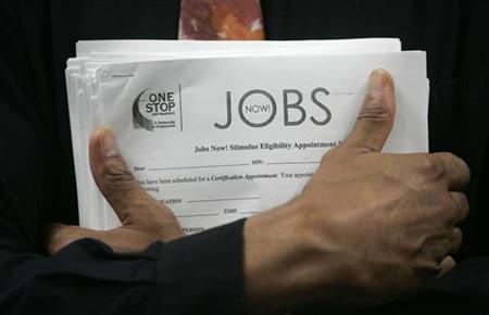 Man carrying a stack of job listings listens to a discussion at the One Stop employment center in San Francisco Man carrying a stack of job listings listens to a discussion at the One Stop employment center in San Francisco