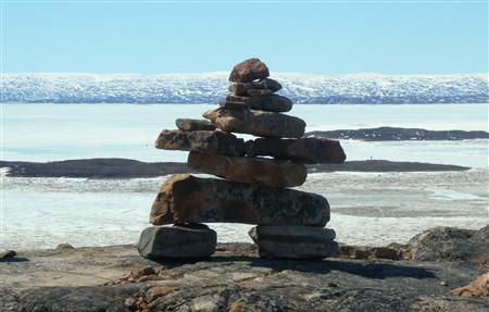 A traditional Inuit inukshuk stone formation looks out over Frobisher Bay near Iqaluit A traditional Inuit inukshuk stone formation looks out over Frobisher Bay near Iqaluit