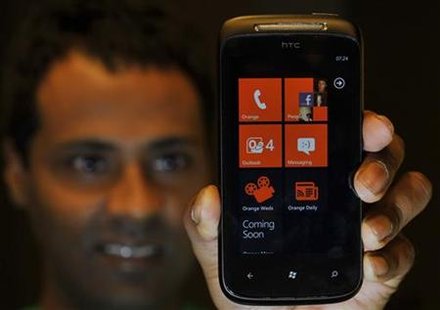 An employee poses with a mobile phone with the new Windows 7 operating system after its arrival in British shops, in central London An employee poses with a mobile phone with the new Windows 7 operating system after its arrival in British shops, in central London