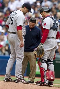 Red Sox pitcher Beckett is attended to by trainer Reynold and catcher Varitek in the fourth inning of their American League MLB game against Red Sox pitcher Beckett is attended to by trainer Reynold and catcher Varitek in the fourth inning of their American League MLB game against