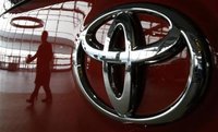 A visitor is reflected on a Toyota vehicle at the company's showroom in Tokyo