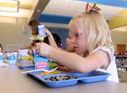A child drinking milk in a school cafeteria A child drinking milk in a school cafeteria
