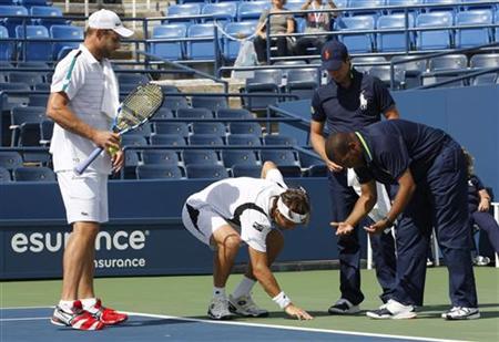 David Ferrer of Spain and Andy Roddick of the U.S. of the examine a spot on the court where water is coming from below the surface at Louis David Ferrer of Spain and Andy Roddick of the U.S. of the examine a spot on the court where water is coming from below the surface at Louis