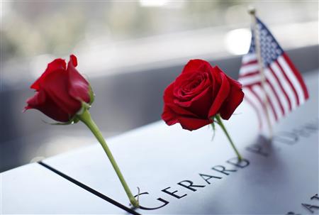 A pair of roses and a U.S. flag are left on one of the panels containing the names of the victims of the attacks on the first day that the 9 A pair of roses and a U.S. flag are left on one of the panels containing the names of the victims of the attacks on the first day that the 9