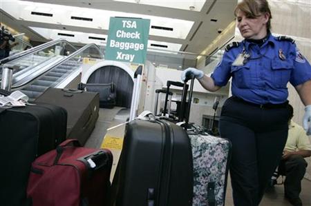 TSA worker loads suitcases at luggage security screening station at Los Angeles International Airport TSA worker loads suitcases at luggage security screening station at Los Angeles International Airport