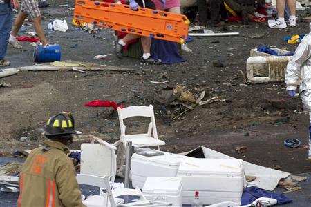 A crater is visible as first responders and people rush to help injured spectators following the crash of a vintage World War Two P-51 Musta A crater is visible as first responders and people rush to help injured spectators following the crash of a vintage World War Two P-51 Musta