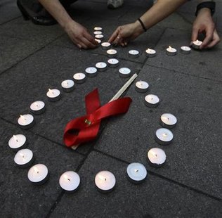 Activists distribute red ribbons and light up candles as they commemorate victims of the Human Immunodeficiency Virus, or HIV, during a flas Activists distribute red ribbons and light up candles as they commemorate victims of the Human Immunodeficiency Virus, or HIV, during a flas